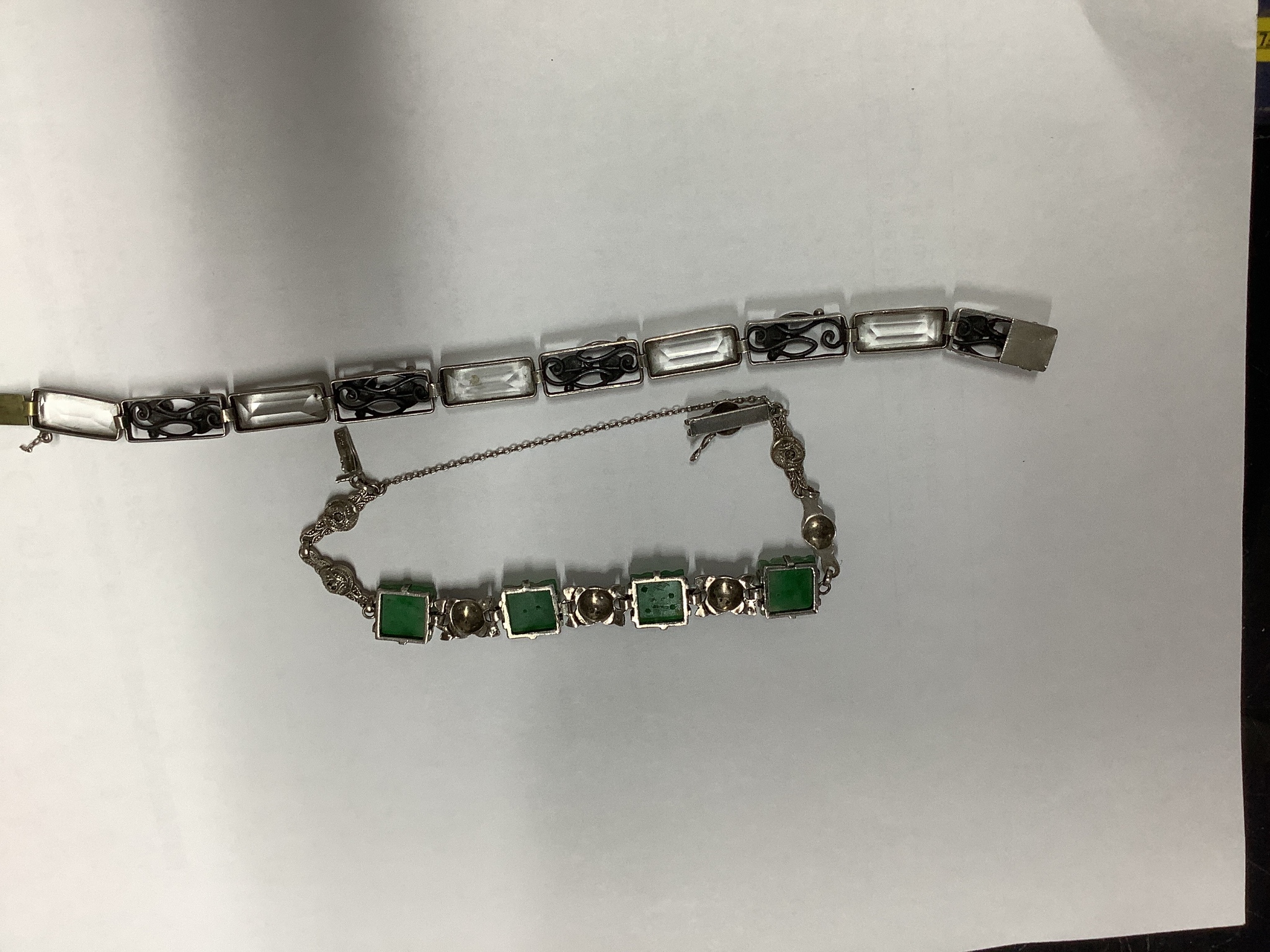 A white metal and carved jade set bracelet and one other bracelet.